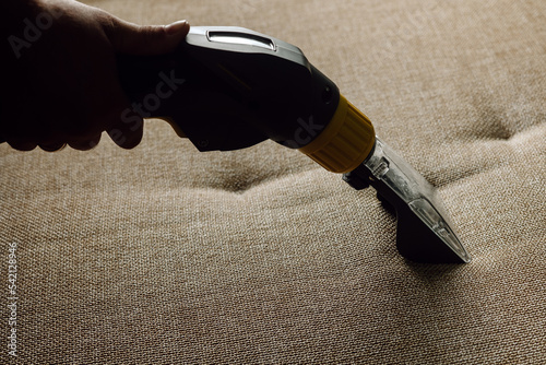 Close-up of a furniture vacuum cleaner and a dirty sofa. Cleaning and house cleaning, housekeeper or special service to keep house clean. Laundry cloth
