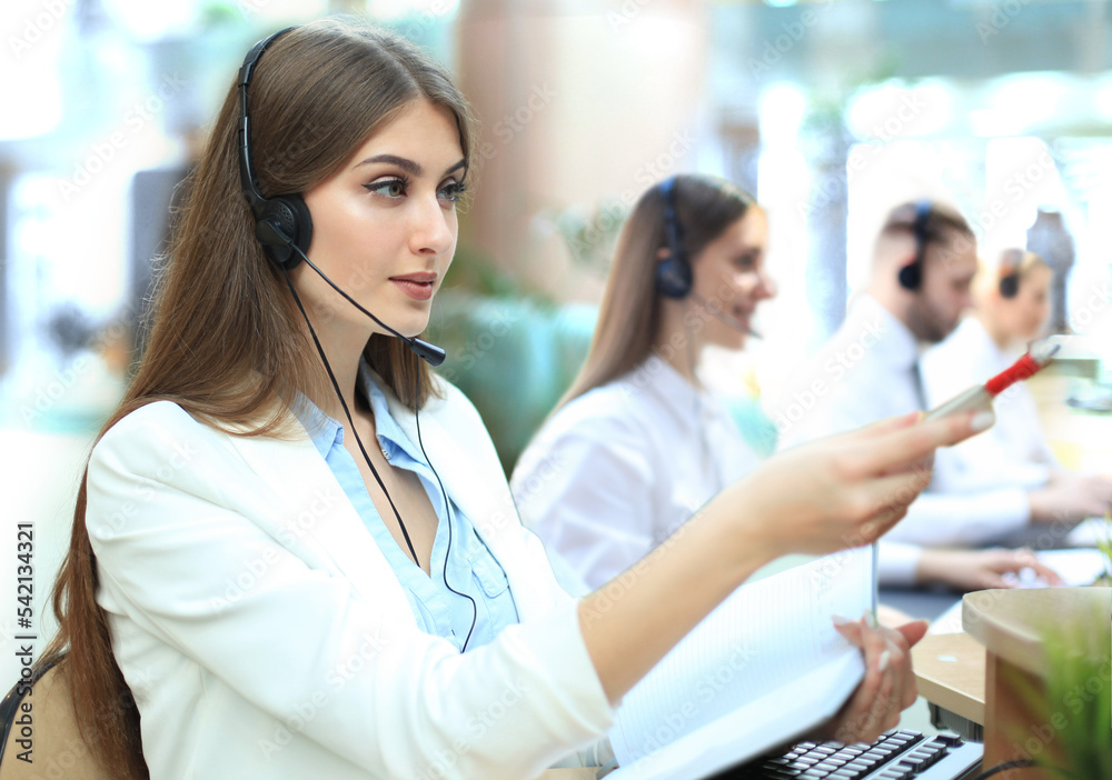 Portrait of call center worker accompanied by her team. Smiling customer support operator at work. Portrait of call center worker accompanied by her team. Smiling customer support operator at work.