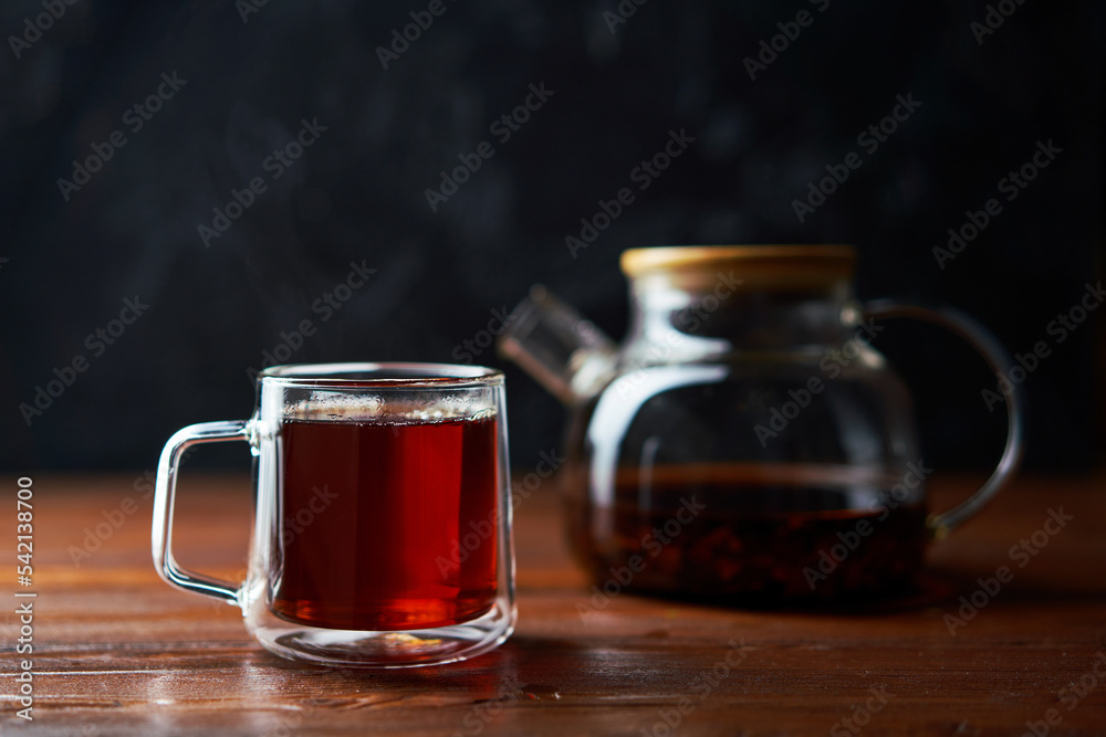 Teapot and cup of tea standing on a brown table Teapot and cup of tea standing on a brown table