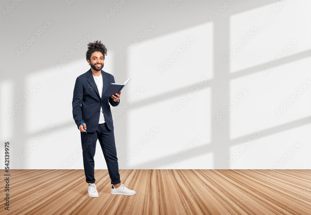 Middle eastern businessman with notebook and pen, full length an Middle eastern businessman with notebook and pen, full length an
