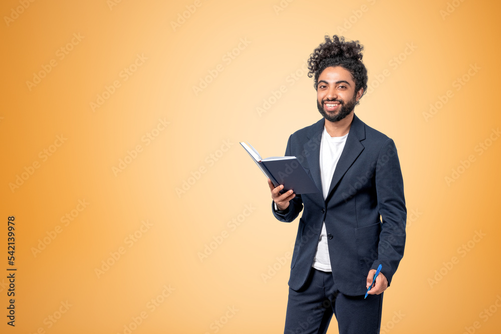 Middle eastern businessman with notebook and pen smiling, copy s