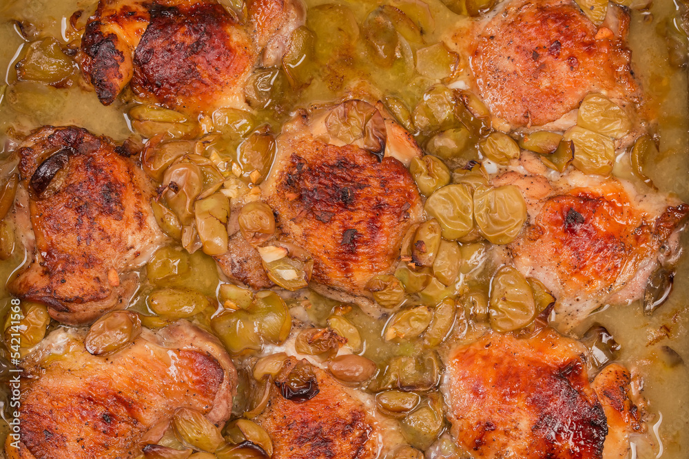 Chicken thighs baked with grape, top view close-up Chicken thighs baked with grape, top view close-up
