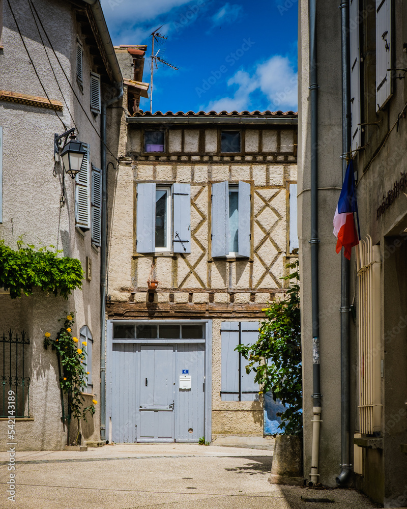 Half timbered house and light blue shutters in the medieval village of Fanjeaux, in the south of France (Aude)