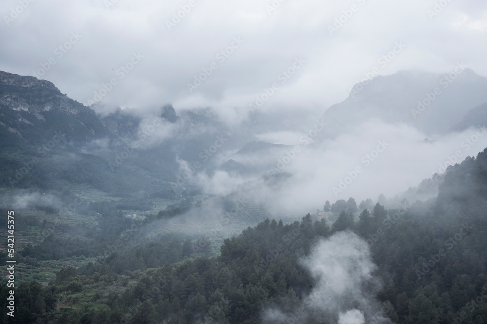 Scenic view of mountain against dramatic sky during foggy weather