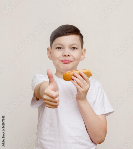 Hot dogs are my favorite. A cute little boy eating a hot dog while outdoors.