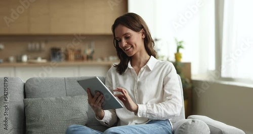 Happy woman hold digital tablet at home, typing message, answers to friend in social media network, working on-line, spend free time on internet use internet connection and modern gadget, tech concept