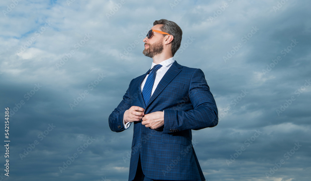 Professional man looking aside sky background. Grizzled man wearing sunglasses. Serious man Professional man looking aside sky background. Grizzled man wearing sunglasses. Serious man