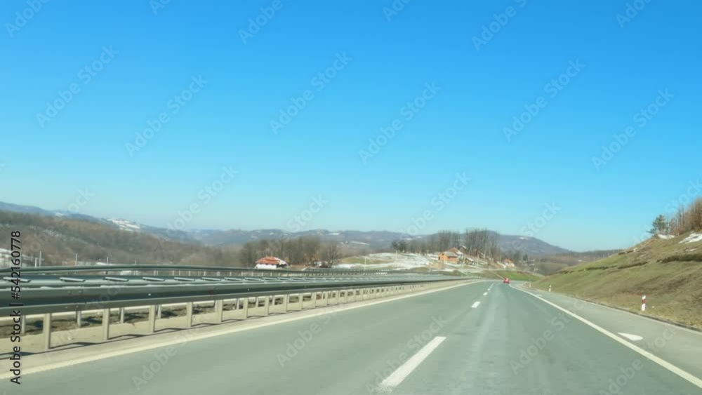 Driving down the highway through Serbia in winter, with snow melting on surrounding hills, dashcam pov driving plate footage Driving down the highway through Serbia in winter, with snow melting on surrounding hills, dashcam pov driving plate footage