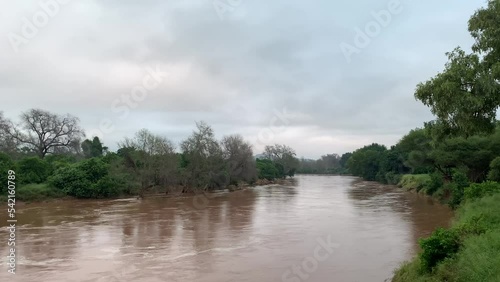 Beautiful shot of Luvuvhu river in flood with trees and cloudy sky in Limpopo province, Africa photo
