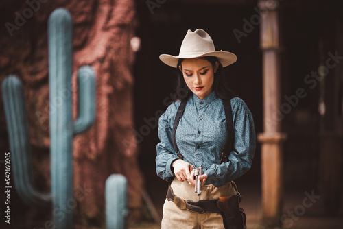 Cowgirl posing with rifle gun on hand to show protected weapon is cowgirl vintage american older style. photo