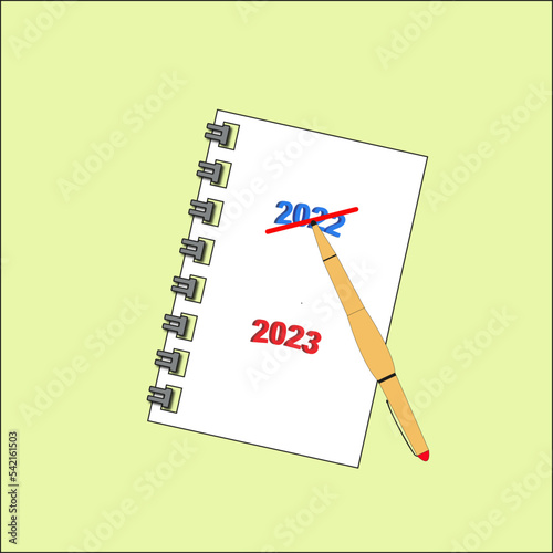 Carnet avec texte année 2022 barré et 2023 et stylo sur fond jaune clair