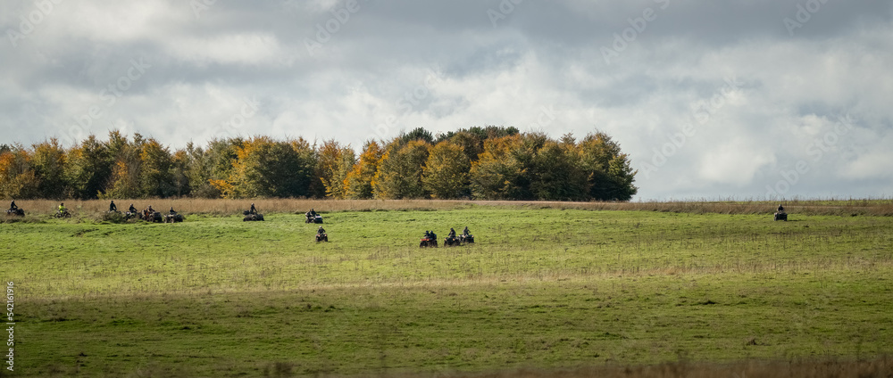 Fototapeta premium quad bikers on a cross-country adventure, cloudy summer sky