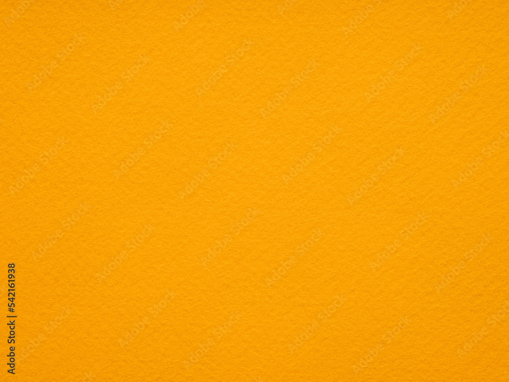 Background of bright Orange felt. Yellow cotton textile close up of fabric texture. Saturated background for seasonal decoration, text, lettering, patchworkor, party greeting and wedding card element.