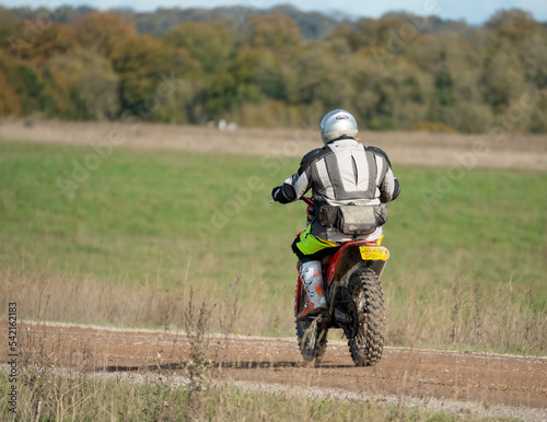 Fototapeta Naklejka Na Ścianę i Meble -  a motor cyclist (biker) riding their off-road motorbike along a stone track on Salisbury Plain, Wiltshire