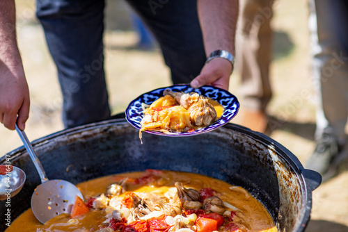 The Dimlama dish is done. Everyone gets their portion on the plate. Kyzylkum, Uzbekistan.