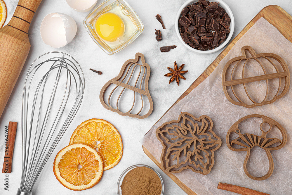 Flat lay composition with cookie cutters and ingredients on white marble table