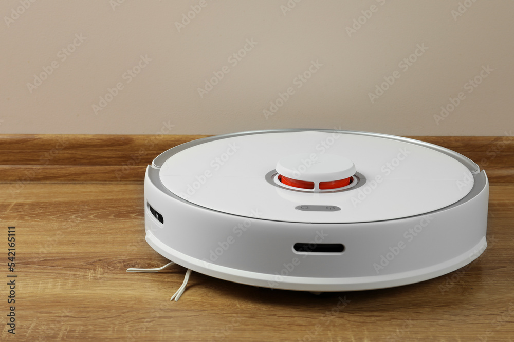 Robotic vacuum cleaner on wooden floor indoors Robotic vacuum cleaner on wooden floor indoors