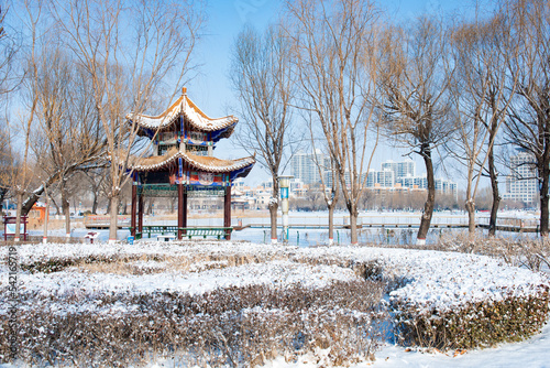 In winter, the river plank road in the city park is covered with snow © Xiangli