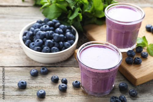 Freshly made blueberry smoothie on wooden table, space for text