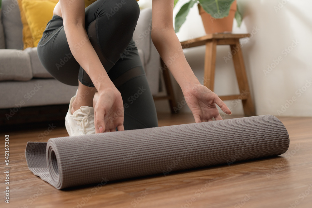 Yoga at home rolling exercise mat in living room for meditation yoga