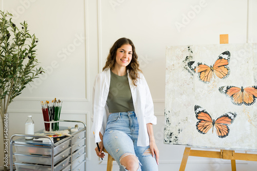 Happy young woman enjoying painting at her studio