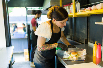Attractive woman chef preparing a fast food sandwich