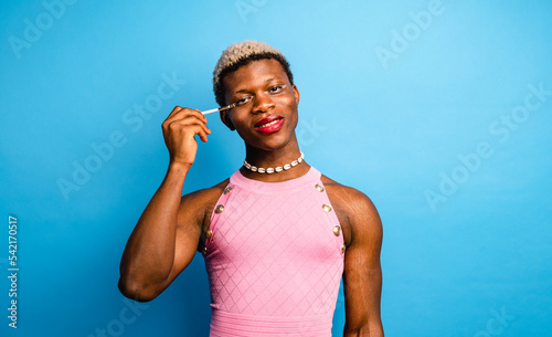 Tableau sur toile Cheerful African androgynous person applying makeup in studio