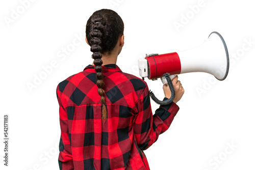 Young Arab woman over isolated background holding a megaphone and in back position