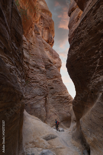 hiker with backpack walking on wadi ghuweir canyon in dana natural reserve