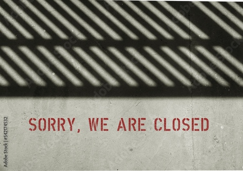 Fence shadow on cement background with screened text SORRY ,WE ARE CLOSED , business retailer closed down permanently - out of business, economy crisis - or temporary closed for renovation