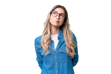 Young Uruguayan woman over isolated background and looking up