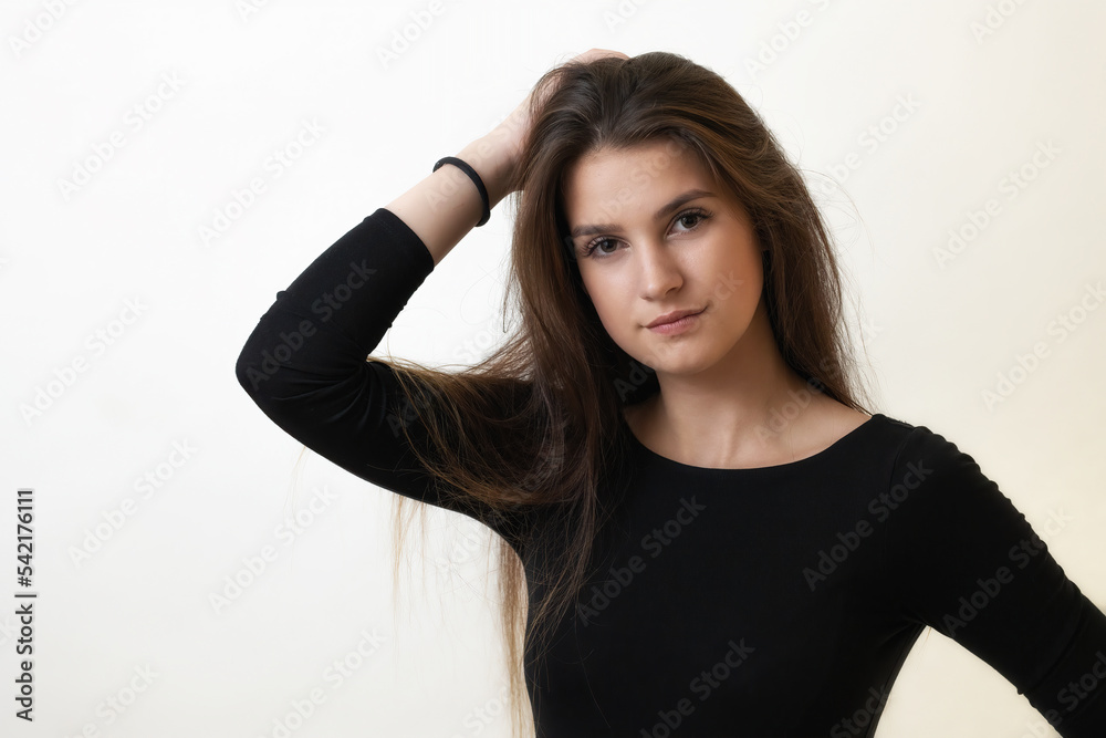 Portrait of serious beautiful girl on the light background. Horizontally. 