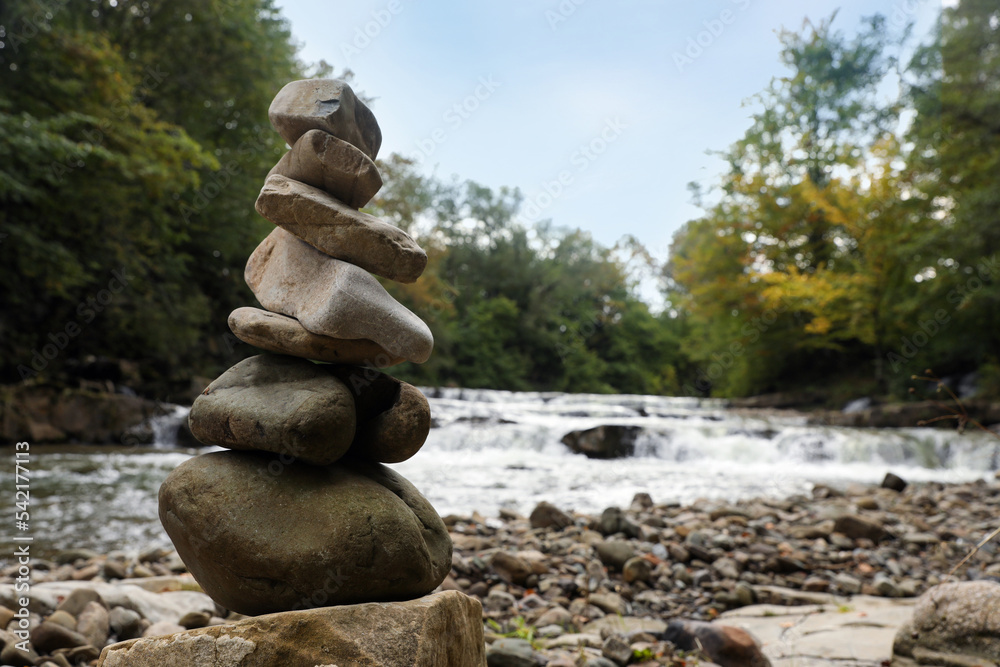 Stack of stones on pebble coast near river Stack of stones on pebble coast near river