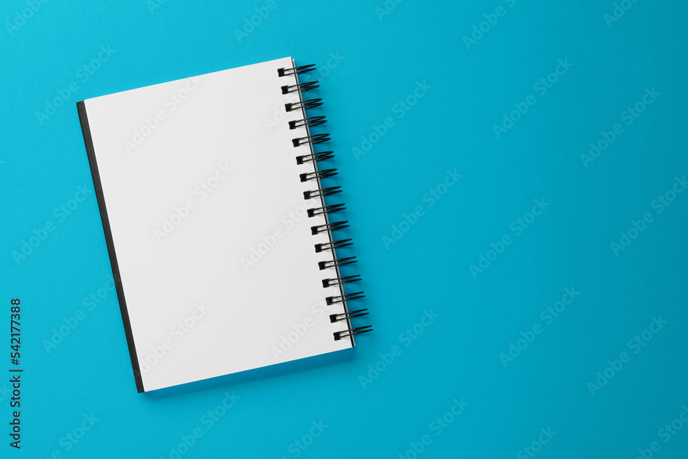 Blank notebook on light blue background, top view. Space for text Blank notebook on light blue background, top view. Space for text