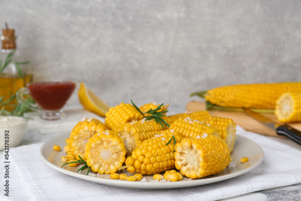 Plate with tasty cooked corn cobs on table indoors Plate with tasty cooked corn cobs on table indoors