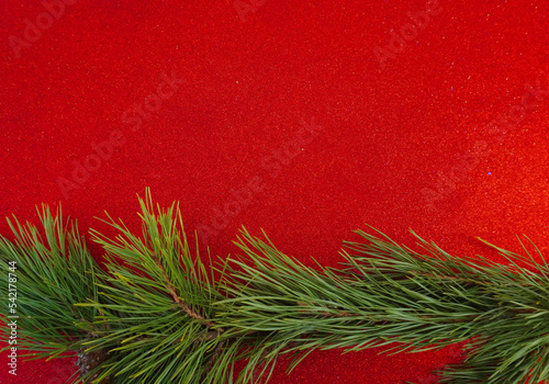 Red Christmas background with Christmas tree branch and Christmas balls and toys