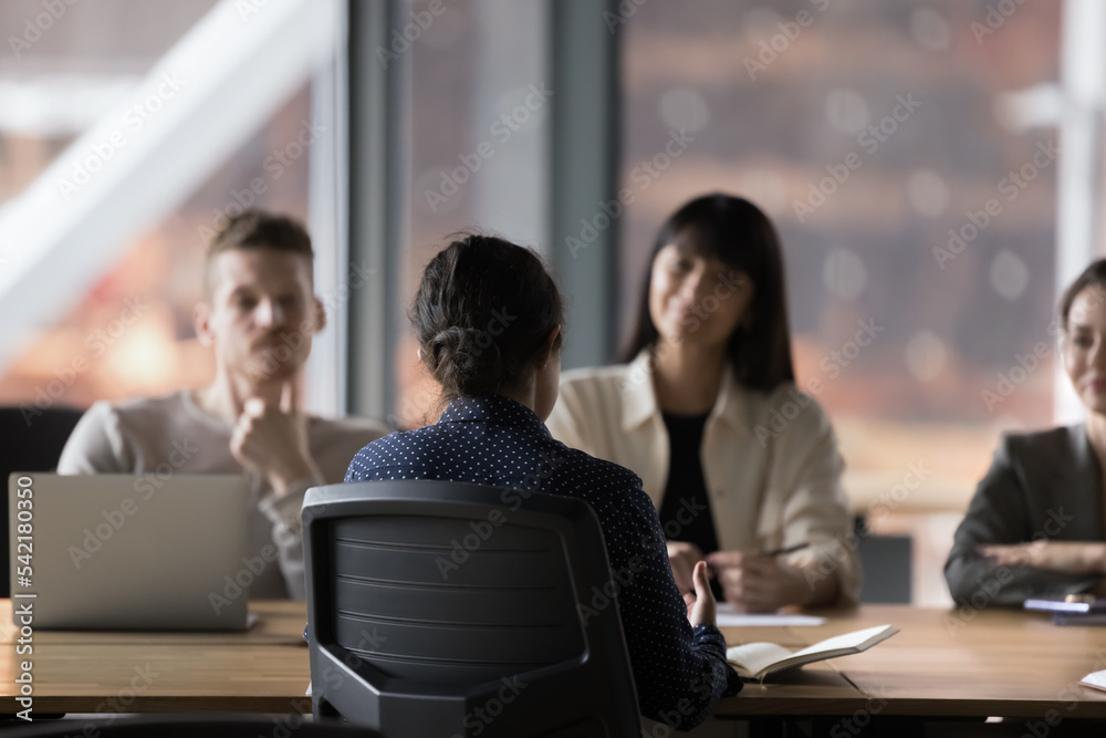 Applicant being interviewed by group of corporate HR managers, seated at table in boardroom in office. Formal meeting of businesspeople take part in negotiations, discuss deal and future cooperation