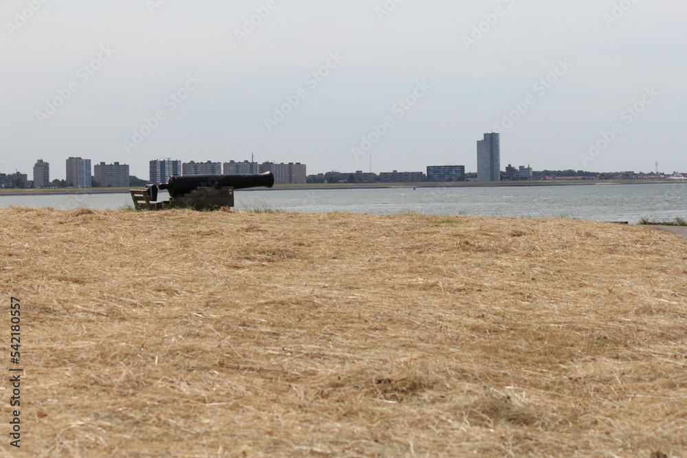 Φωτογραφία a canon at the seawall at the dutch coast of the westerschelde sea and the skyli