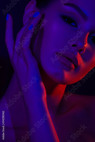 Woman on pink blue neon background.