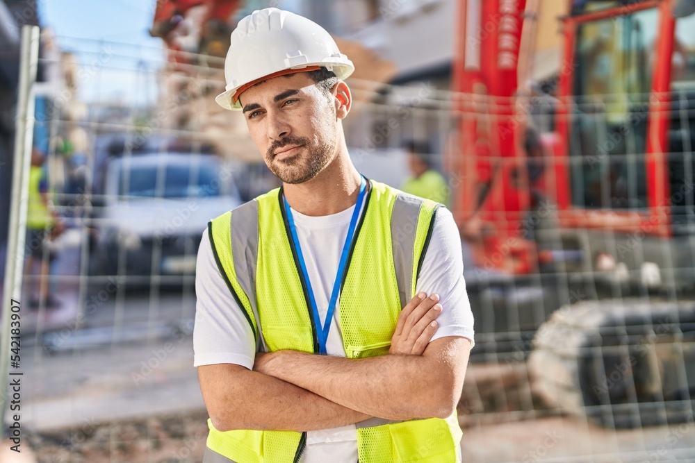 Young hispanic man architect standing with arms crossed gesture at street Young hispanic man architect standing with arms crossed gesture at street