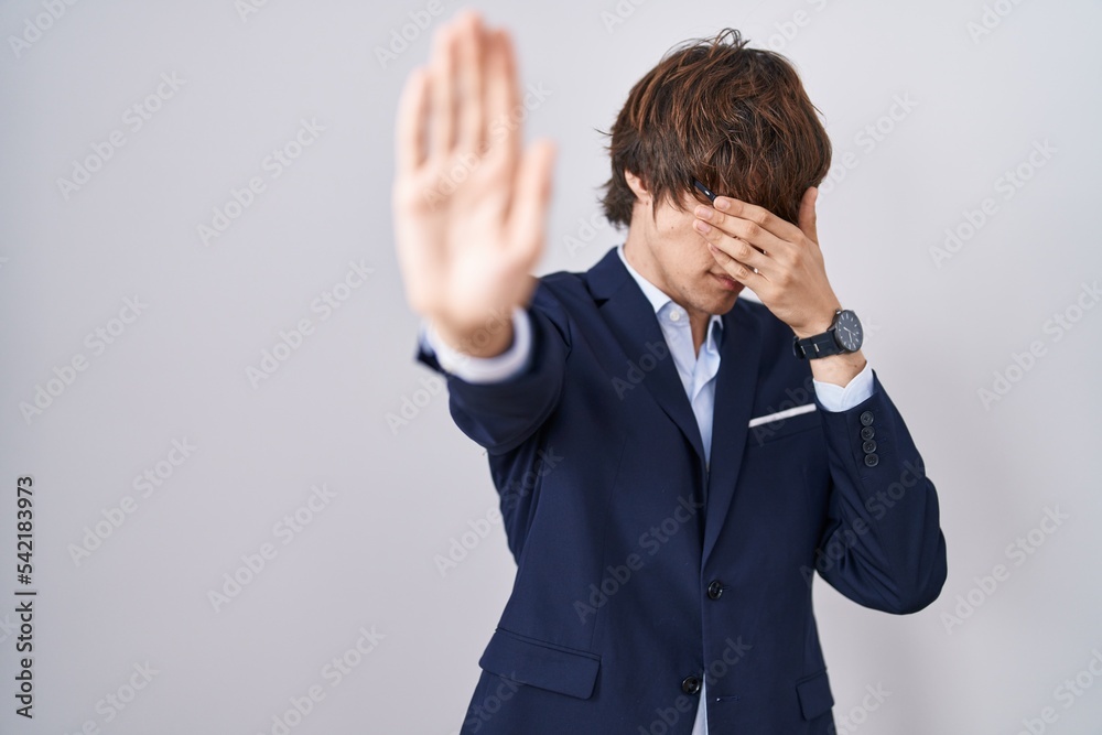 Hispanic business young man wearing glasses covering eyes with hands and doing stop gesture with sad and fear expression. embarrassed and negative concept. Hispanic business young man wearing glasses covering eyes with hands and doing stop gesture with sad and fear expression. embarrassed and negative concept.