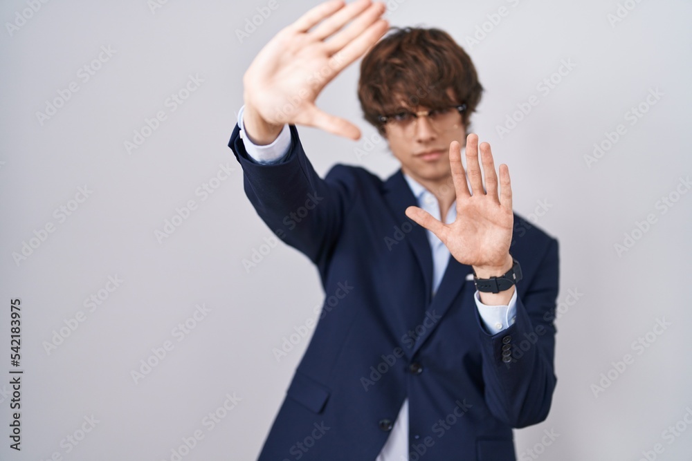 Hispanic business young man wearing glasses doing frame using hands palms and fingers, camera perspective Hispanic business young man wearing glasses doing frame using hands palms and fingers, camera perspective