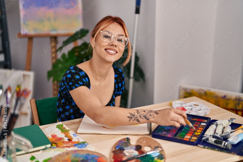 Fototapeta premium Young caucasian woman artist smiling confident drawing on notebook at art studio