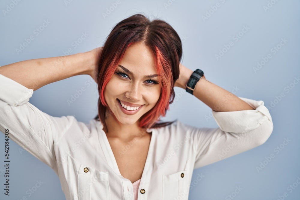 Young caucasian woman wearing casual white shirt over isolated background relaxing and stretching, arms and hands behind head and neck smiling happy Young caucasian woman wearing casual white shirt over isolated background relaxing and stretching, arms and hands behind head and neck smiling happy