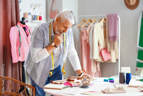 Mature fashion designer working with fabric in studio