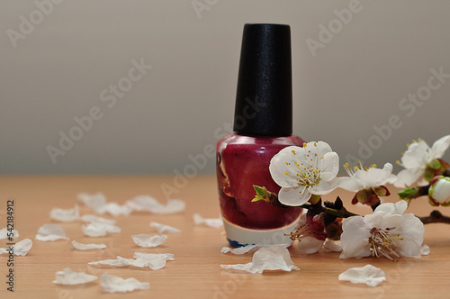 Apricot blossoms displayed with a red bottle of nail polish