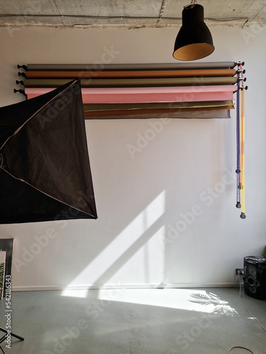 Photo studio interior. Large room with photo backgrounds and a lamp. Sunlight in the studio
