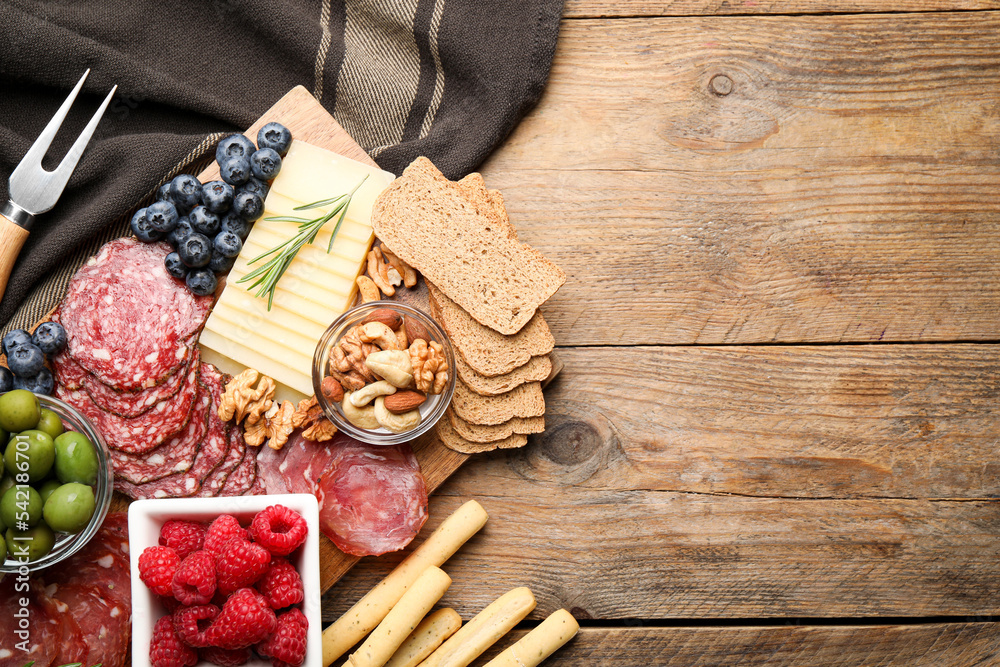 Snack set with delicious Parmesan cheese on wooden table, flat lay. Space for text