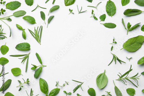Frame made with different aromatic herbs on white background, flat lay. Space for text