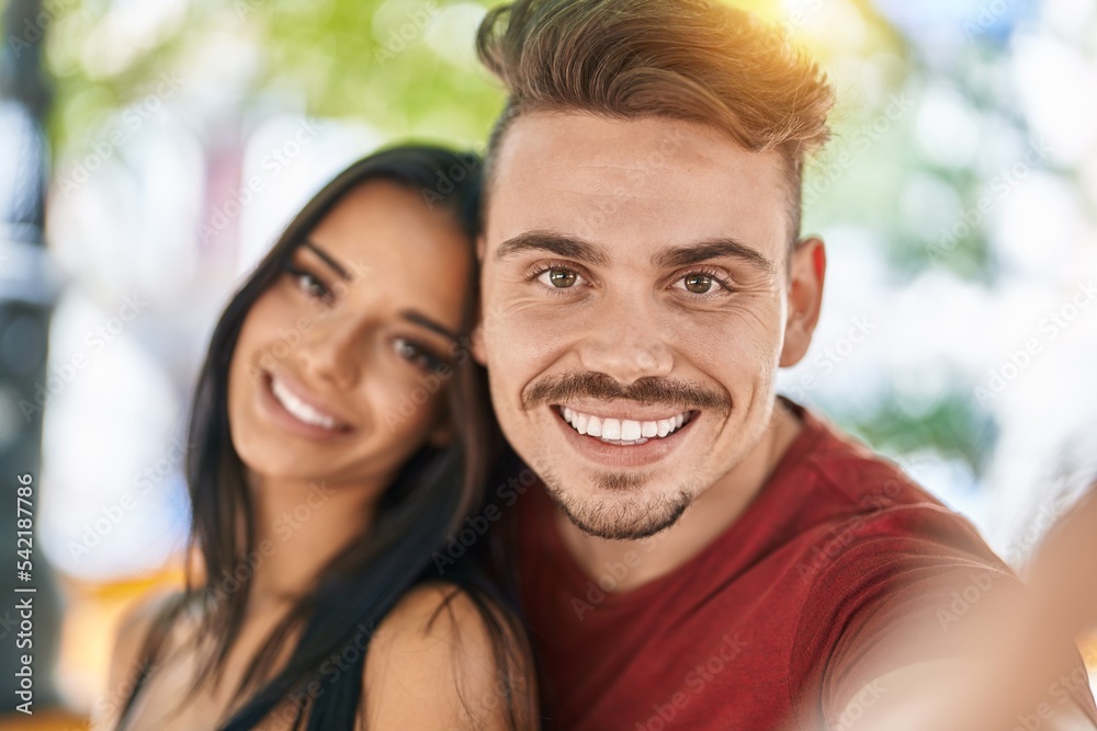 Man and woman couple making selfie by smartphone at park Man and woman couple making selfie by smartphone at park